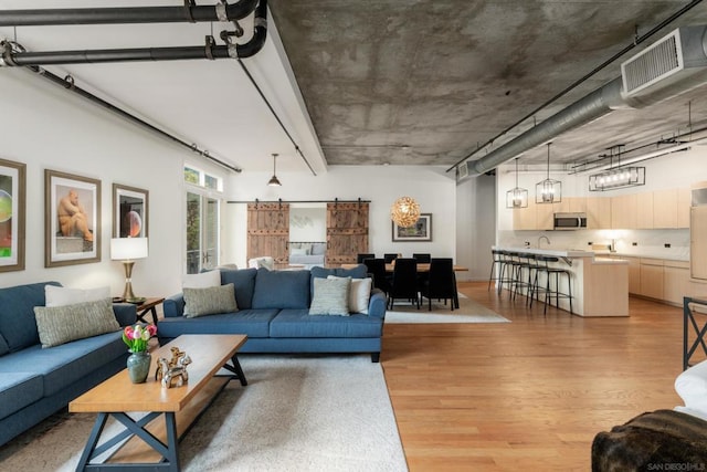 living room featuring light hardwood / wood-style flooring and a barn door