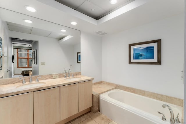 bathroom with tile patterned floors, a bath, and vanity