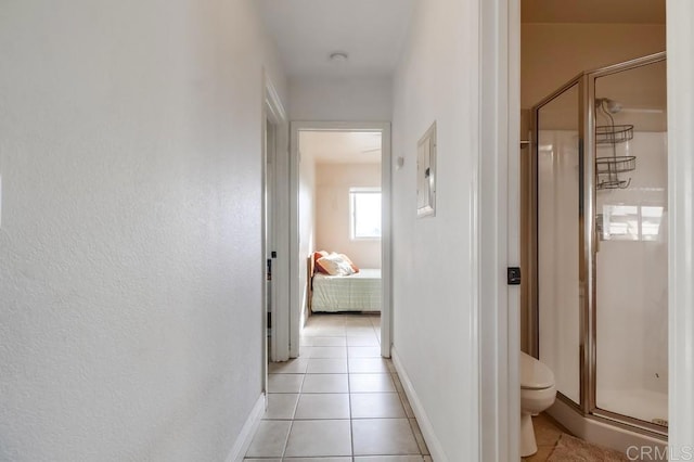 corridor with light tile patterned floors and baseboards