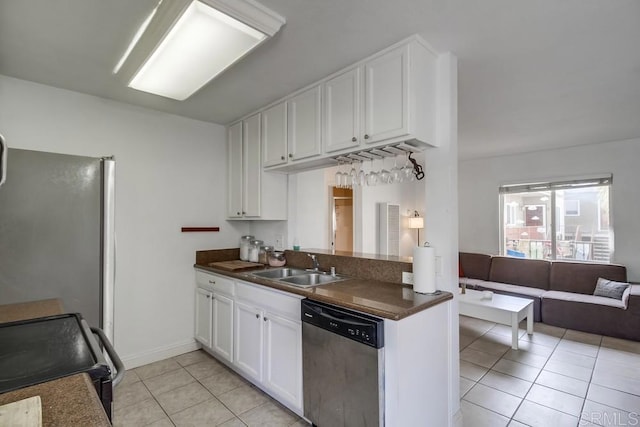 kitchen featuring stainless steel appliances, dark countertops, light tile patterned flooring, and a sink