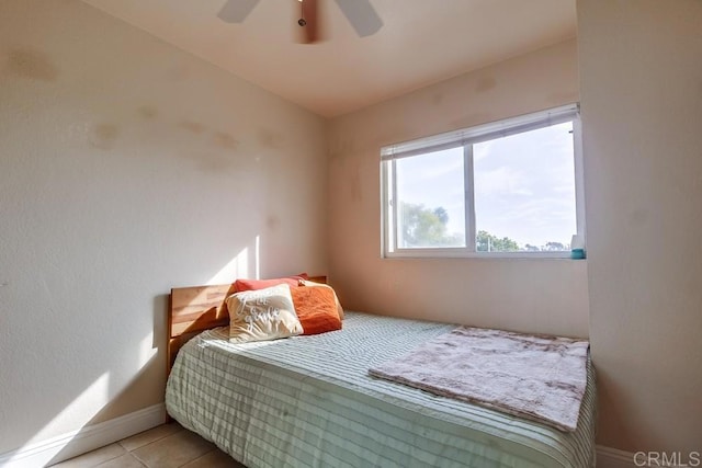 bedroom featuring a ceiling fan, light tile patterned flooring, and baseboards