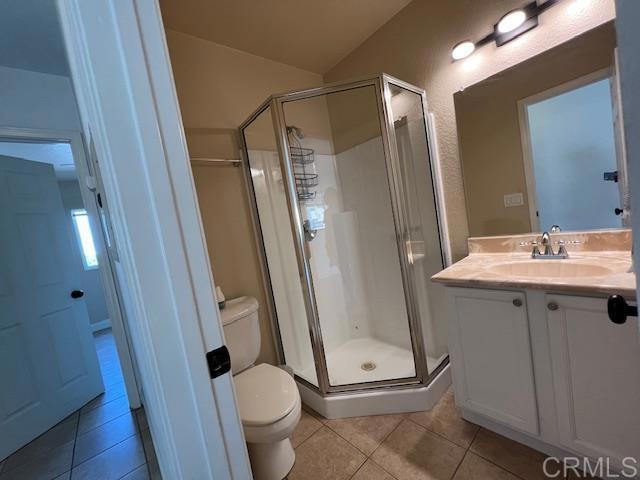 bathroom with toilet, a shower stall, tile patterned flooring, and vanity