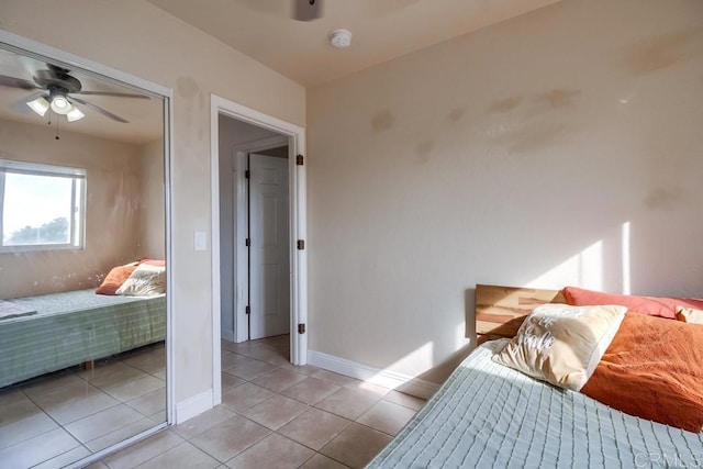 bedroom featuring ceiling fan, baseboards, and light tile patterned floors