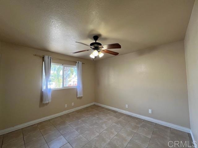 unfurnished room featuring a ceiling fan, a textured ceiling, and baseboards