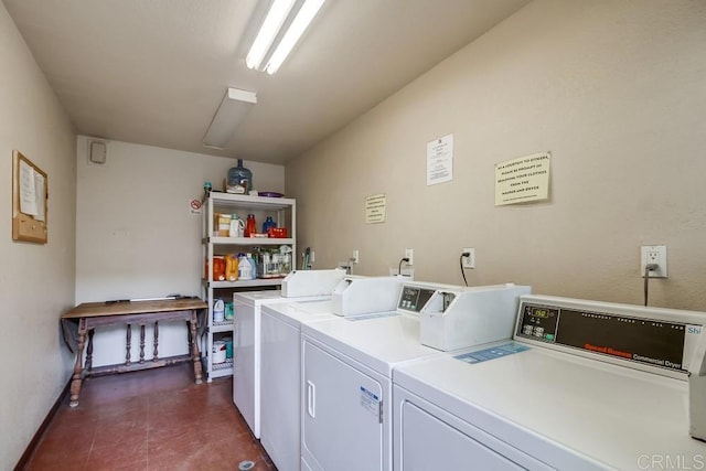 shared laundry area with dark tile patterned floors and washing machine and clothes dryer