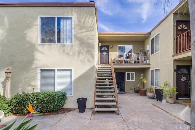 back of house with a patio area, stairway, and stucco siding