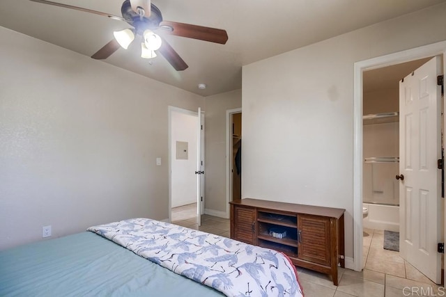 bedroom featuring a ceiling fan, light tile patterned flooring, baseboards, and ensuite bathroom