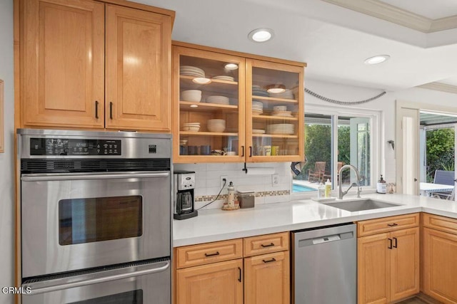 kitchen featuring sink, appliances with stainless steel finishes, backsplash, ornamental molding, and light brown cabinets