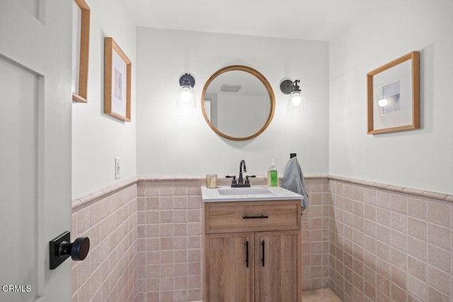 bathroom with vanity and tile walls