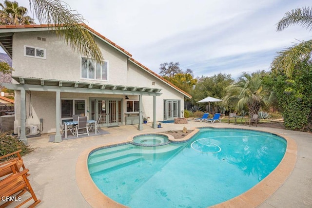 view of pool with a patio and an in ground hot tub