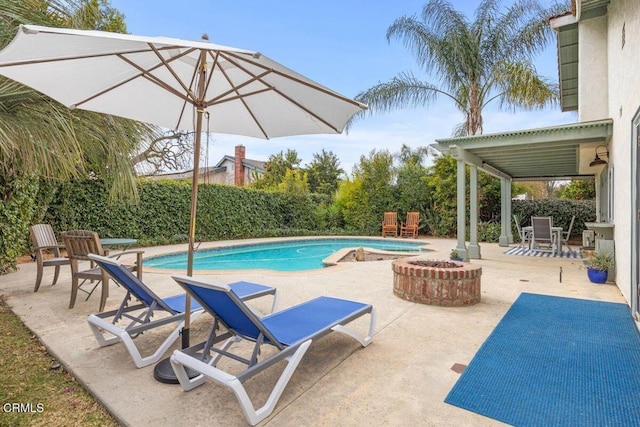 view of swimming pool featuring an outdoor fire pit and a patio