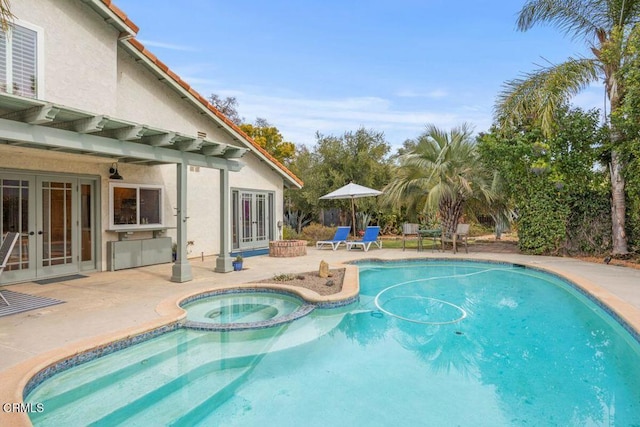 view of swimming pool featuring an in ground hot tub, a patio, and french doors