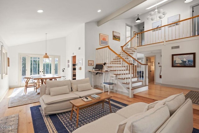 living room with light hardwood / wood-style flooring, high vaulted ceiling, and french doors