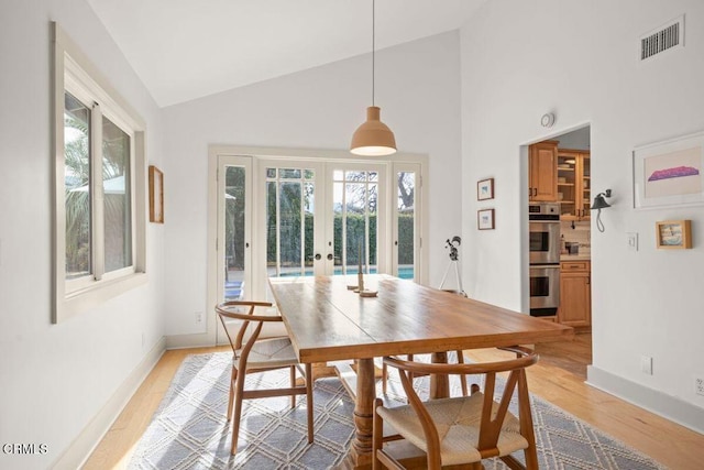 dining space with french doors, plenty of natural light, and light wood-type flooring