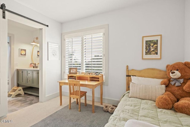 carpeted bedroom with connected bathroom, sink, and a barn door