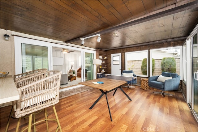 sunroom / solarium with rail lighting, a wealth of natural light, and wooden ceiling