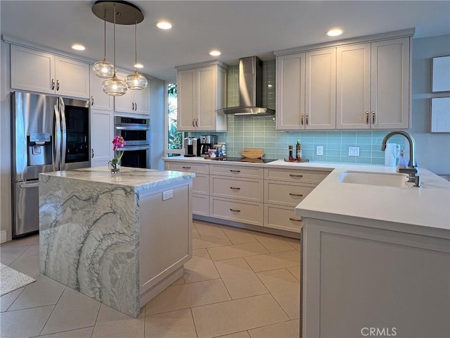 kitchen featuring a kitchen island, appliances with stainless steel finishes, sink, and wall chimney range hood