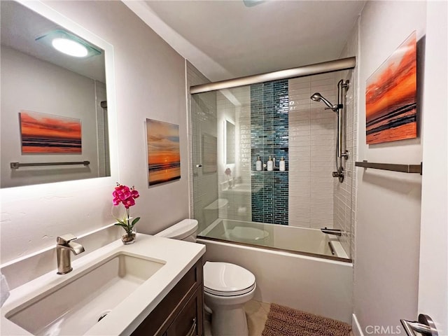 full bathroom featuring toilet, vanity, and shower / bath combination with glass door