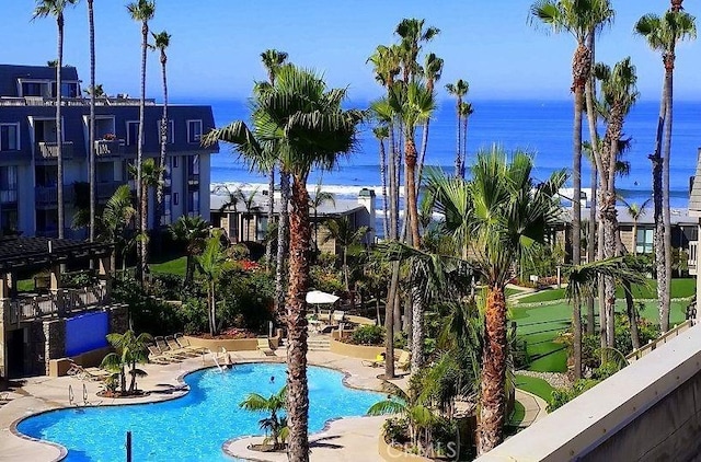 view of swimming pool featuring a water view and a patio area