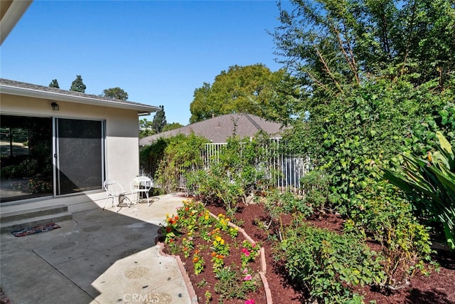 view of patio / terrace with a vegetable garden and fence