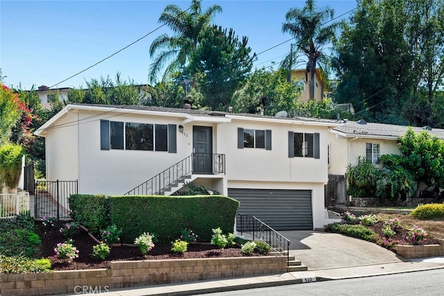 single story home with fence, concrete driveway, stairs, stucco siding, and a garage