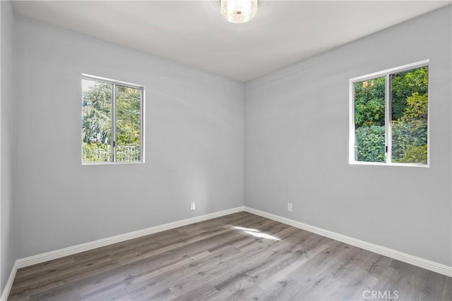 empty room featuring baseboards and wood finished floors