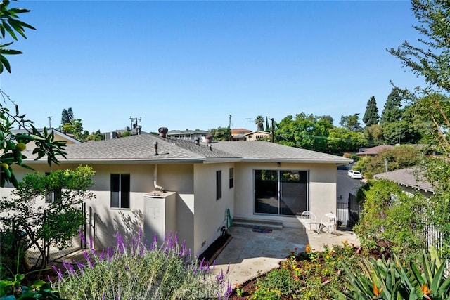 back of house with stucco siding, a patio, roof with shingles, and fence