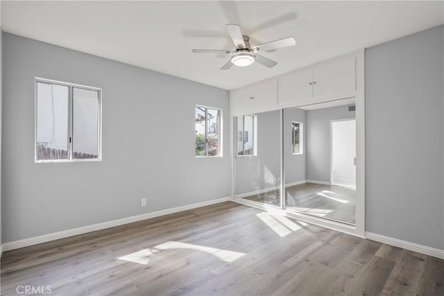 unfurnished bedroom featuring ceiling fan, light wood finished floors, and baseboards