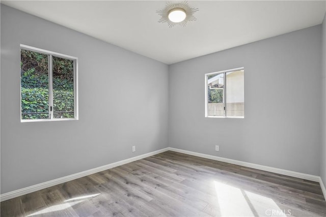 spare room with wood finished floors and baseboards