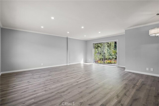 empty room featuring crown molding and wood-type flooring