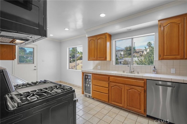 kitchen featuring beverage cooler, black appliances, tasteful backsplash, and a sink