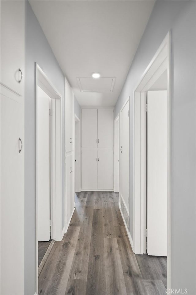 hall with attic access and wood finished floors