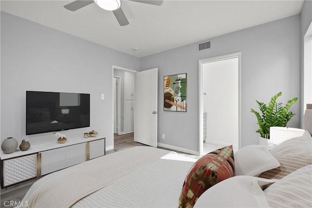 bedroom featuring visible vents, ceiling fan, baseboards, and wood finished floors