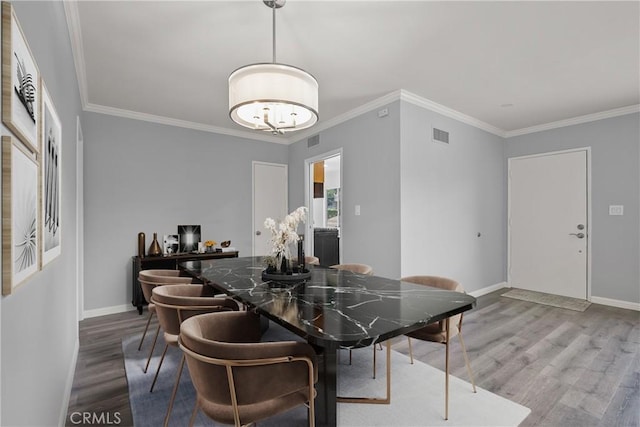 dining area with crown molding, baseboards, and wood finished floors