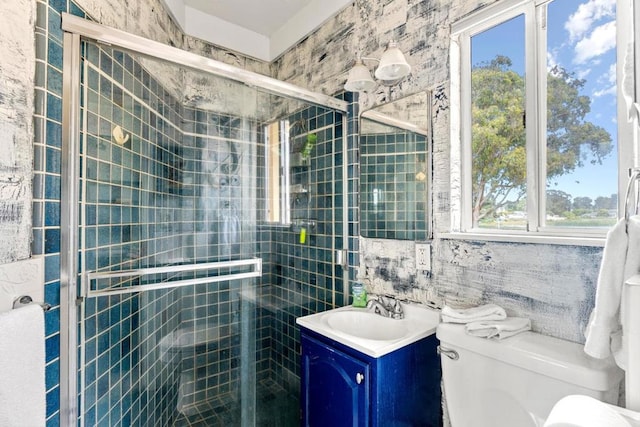 bathroom featuring vanity, toilet, tile walls, and a healthy amount of sunlight