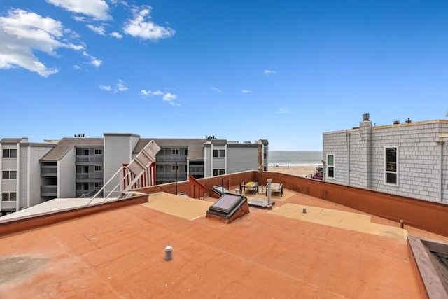 view of patio / terrace with a water view and a view of the beach