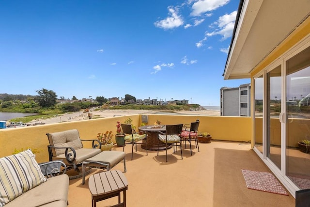 view of patio / terrace with a balcony and a water view