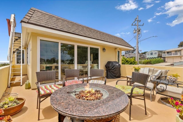 view of patio / terrace featuring area for grilling and an outdoor living space with a fire pit