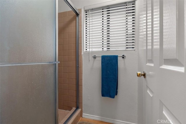 bathroom featuring a stall shower and baseboards