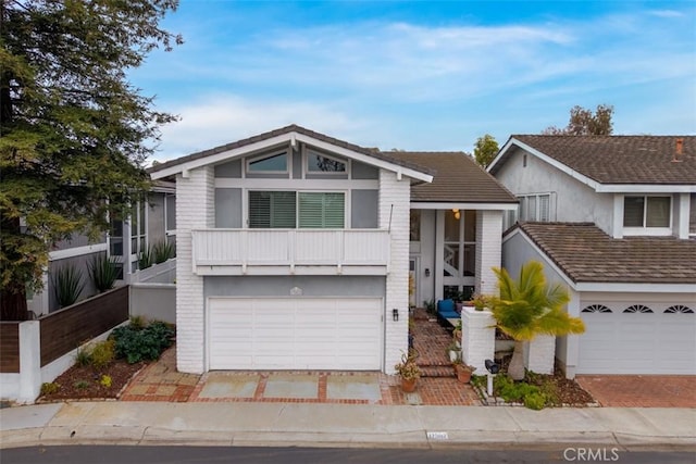 view of front of home with driveway, a balcony, and an attached garage