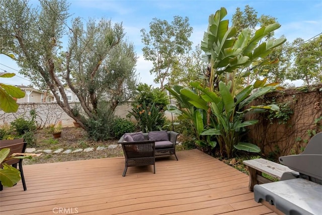 wooden terrace featuring a fenced backyard and an outdoor living space