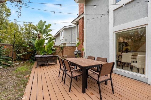 wooden deck featuring outdoor dining area, outdoor lounge area, and fence