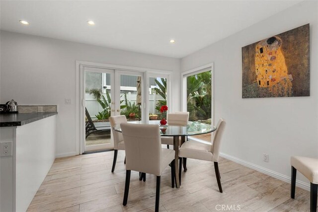 dining space with french doors and light wood-type flooring