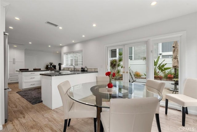 dining room featuring light wood-type flooring, recessed lighting, visible vents, and french doors