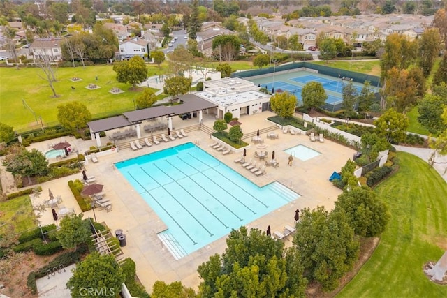 community pool with a residential view and a patio