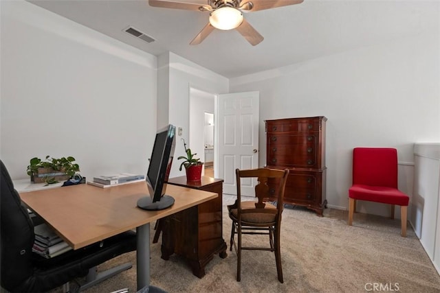 office space with ceiling fan, visible vents, and light colored carpet