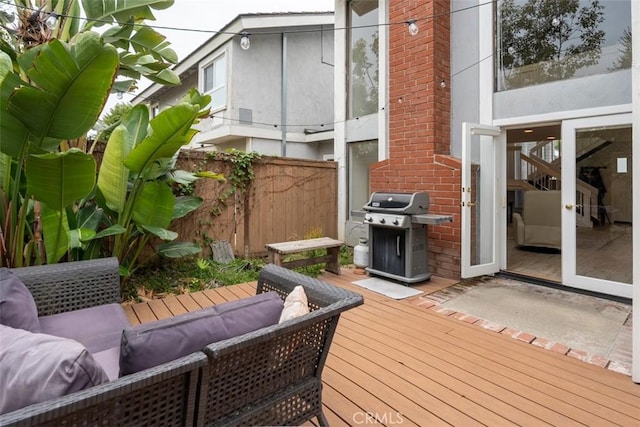 wooden terrace with a grill, an outdoor living space, and fence