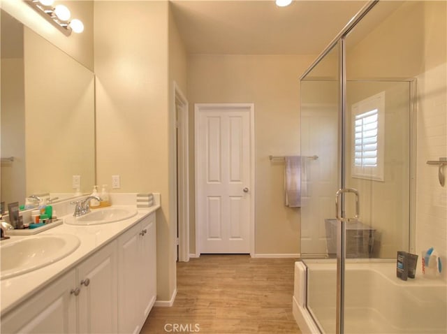 bathroom with a shower with door, vanity, and hardwood / wood-style floors