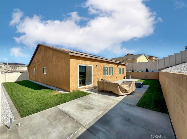 rear view of property featuring a patio and a yard