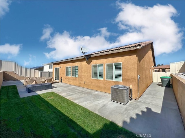 rear view of property with a yard, central AC, and a patio area